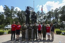 Retired Air Force Col. Gary West stands with Marines and teammates after a flag folding ceremony on Marine Corps Air Station New River, Sept. 1. West is riding 2,500 miles to raise awareness of the sacrifices of fallen service members and their families.