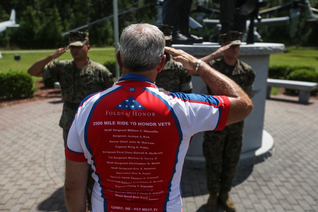 Retired Air Force Col. Gary West salutes the American flag during a flag folding ceremony on Marine Corps Air Station New River, Sept. 1. West is riding 2,500 miles to raise awareness of the sacrifices of fallen service members and their families.