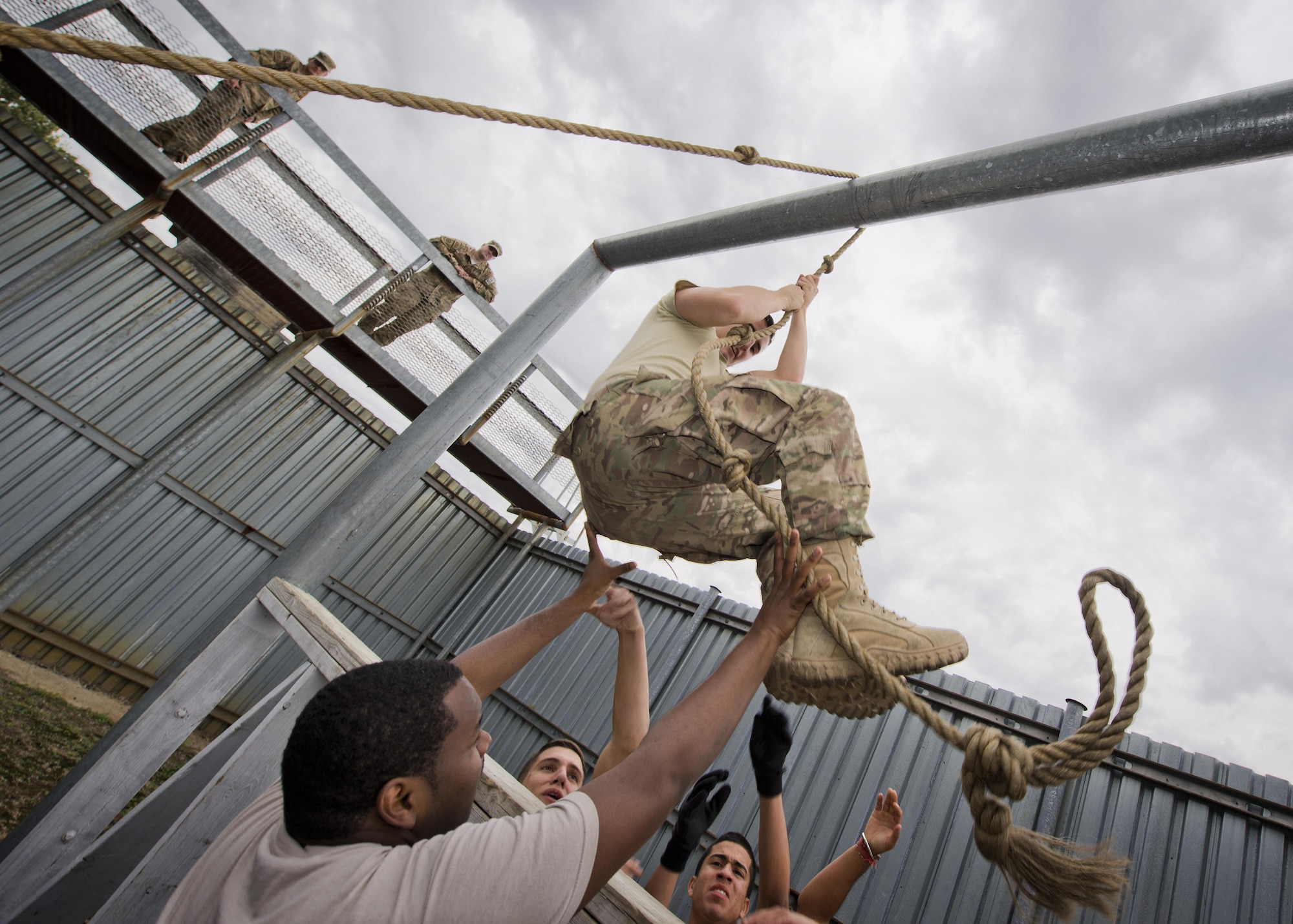 Members of the 91st Security Forces Group swing an Airman through an obstacle at Camp Grafton Training Center, N.D., Sept. 7, 2016. The goal of the obstacle is to move the team through the metal bars, without touching wooden supports, using only a rope. (U.S. Air Force photo/Airman 1st Class J.T. Armstrong)