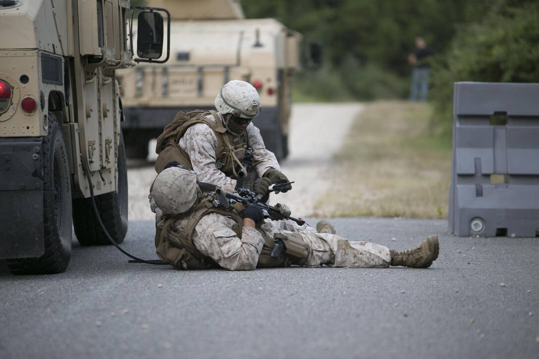 Sgt. Jean Saraka, Fleet Anti-Terrorism Support Team, Marine Corps Security Force Regiment, treats a simulated casualty after opposing forces ambushed the convoy during training aboard the Naval Expeditionary Combat Center, Naval Weapons Station Yorktown, Va., Aug. 31, 2016. The Marines conducted convoy operations training to sharpen their skills when faced with real-world scenarios such as improvised explosive device threats and road block ambushes. (Official U.S. Marine Corps photo by Sgt. Calvin Shamoon/ Released)