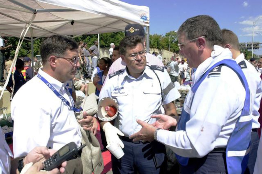 Lt. Gen.l (Dr.) Paul Carlton Jr., surgeon general of the Air Force, right, Master Sgt. Noel Sepulveda, center, and Pentagon employees pitch in to help where needed after hijacked American Airlines Flight 77 crashed into the Pentagon, Sept. 11, 2001. Air Force photo by Jim Miller