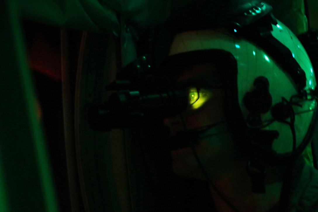 Lance Cpl. Jonathan Landis gazes through the window a KC-130J Super Hercules while wearing night vision goggles during an aerial refueling mission over the Atlantic Ocean Sept. 7, 2016. The mission of Marine Aerial Refueler Transport Squadron 252 is to support the Marine Air Ground Task Force commander by providing air-to-air refueling, assault support, and offensive air support, day or night under all weather conditions during expeditionary, joint, or combined operations.  VMGR-252 conducted aerial refuels for AV-8B Prowlers, EA-6B Harriers, and F-35B Lightnings off the coast of North Carolina to provide routine training for both the pilots and crew members. Landis is a KC-130 crew master with VMGR-252. (U.S. Marine Corps Photo by Lance Cpl. Mackenzie Gibson/Released)