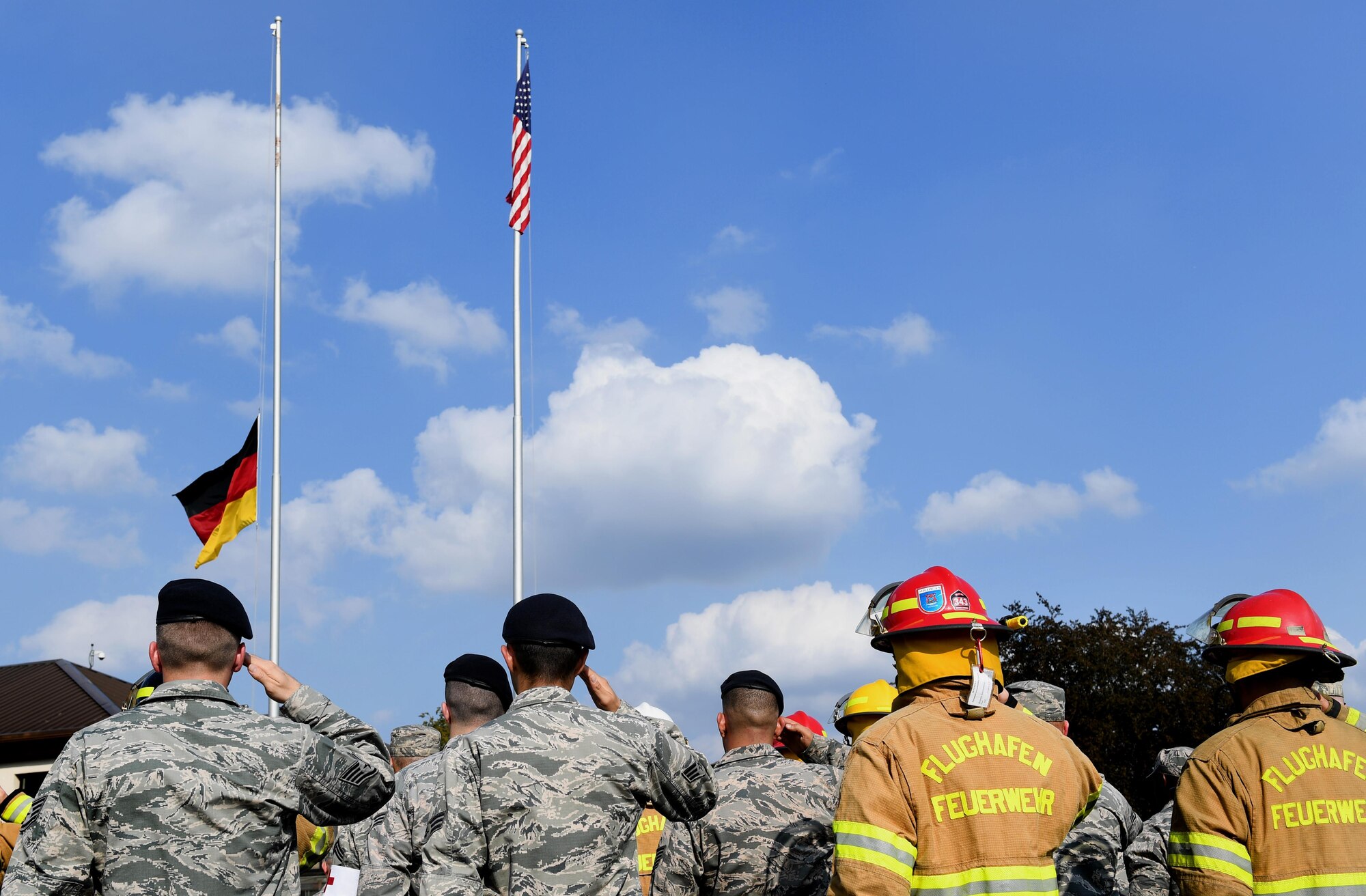 Airmen from the 86th Airlift Wing salute during the lowering of the German flag Sept. 9, 2016 at Ramstein Air Base, Germany. The Airmen were participating in a 9/11 Memorial Retreat Ceremony to honor the 2,977 lives lost during the attacks. (U.S. Air Force photo/Senior Airman Tryphena Mayhugh) 
