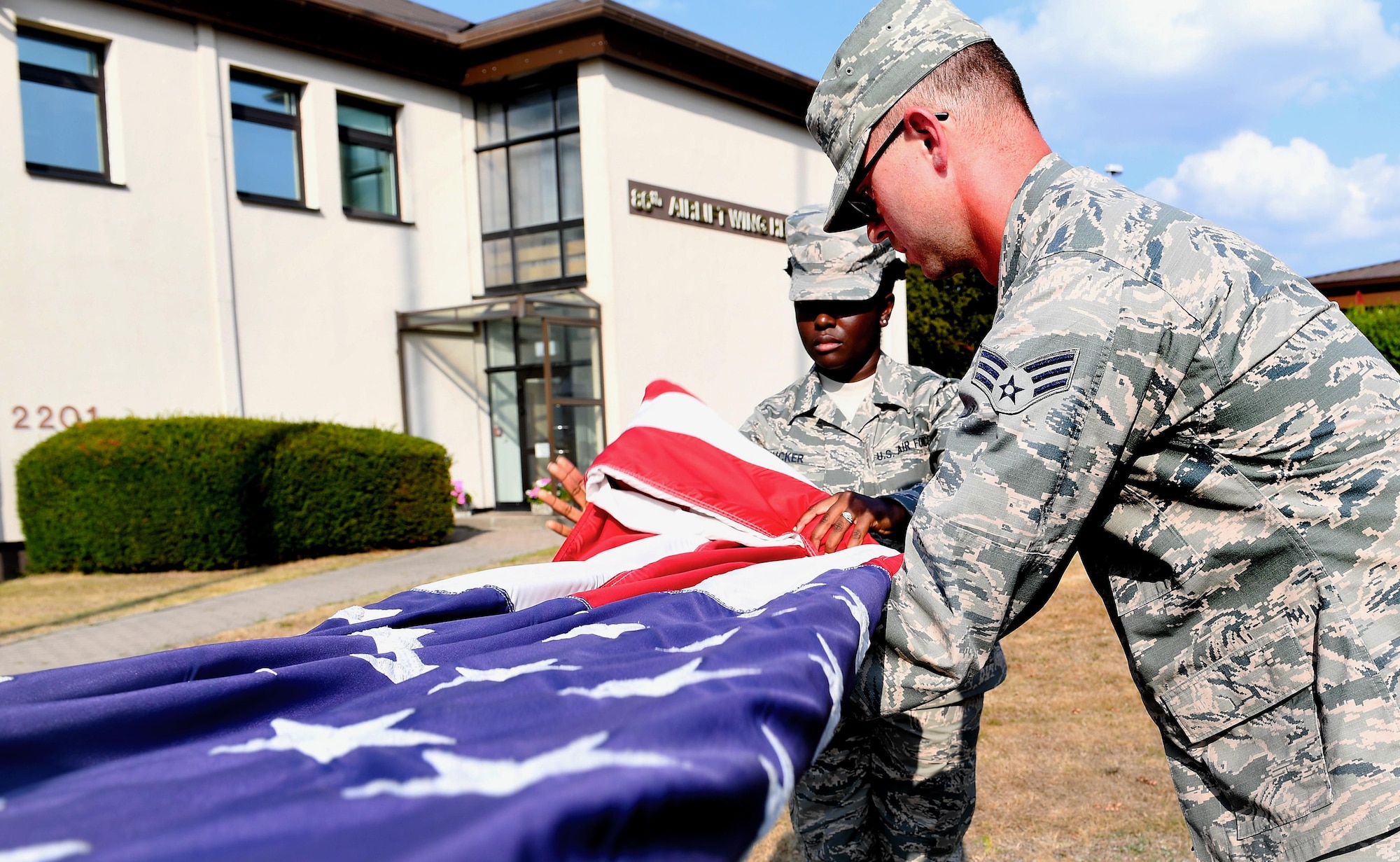From left, Senior Airman Daneeka Mucker, 86th Logistic Readiness Squadron hazmart pharmacy specialist, and Senior Airman Anthony Tepen, 86th Vehicles Readiness Squadron vehicle maintenance technician, fold the American flag during a 9/11 Memorial Retreat Ceremony Sept. 9, 2016 at Ramstein Air Base, Germany. 2,977 people lost their lives in the attacks, including 343 firefighters, 72 law enforcement officers and 55 military personnel who were first responders at the World Trade Center. (U.S. Air Force photo/Senior Airman Tryphena Mayhugh) 