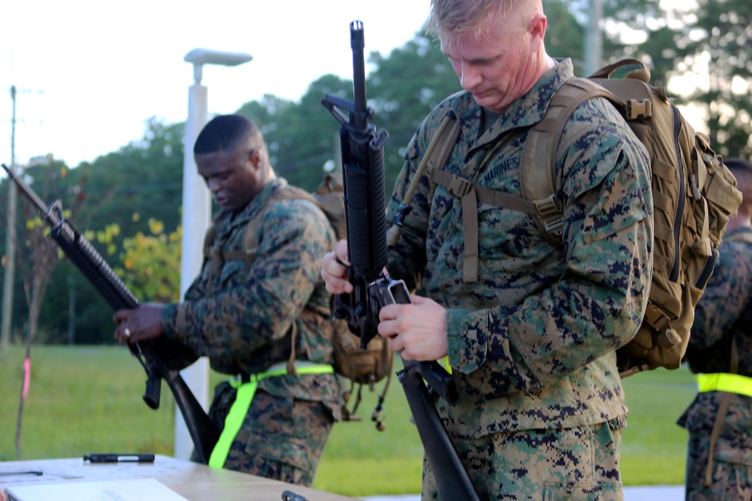 Gunnery Sgt. Nathan Sparks, left, and Maj. Robert Walker reassemble an M-16 assault rifle during Marine Tactical Air Command Squadron 28’s second annual Warrior Day at Marine Corps Air Station Cherry Point, N.C., Sept. 1, 2016. More than 50 Marines participated in MTACS-28's warrior day which included six different stations that incorporated ground fighting matches, an M-16 service rifle disassembly and reassembly, kayaking, radio set-up, repelling, and a 50-yard Humvee pull. Marines worked hand-in-hand to complete events as a team while sharing diverse leadership styles, years of experience and espirit de Corps. MTACS-28 is part of Marine Air Control Group 28, 2nd Marine Aircraft Wing. (U.S. Marine Corps photo by Cpl. Jason Jimenez/Released)