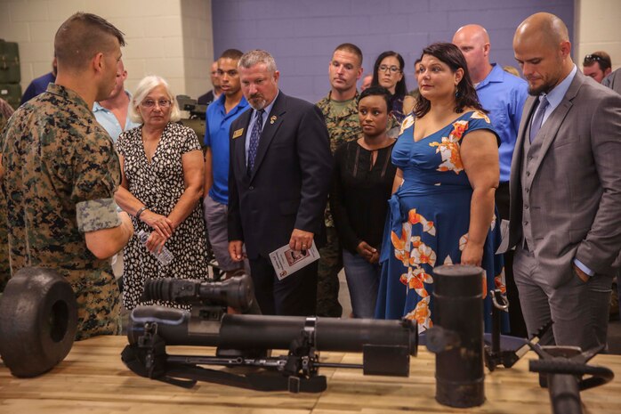 Staff Sgt. Joseph W. Martin (left), chief instructor of Advanced Antitank Missle Gunner Course, gives a brief on the shoulder fire missle launch assault weapon during the tour of the Ouellette Hall at Camp Geirger on Marine Corpe Installation East- Marine Corps Base Camp Lejeune Aug. 31. The hall is dedicated to Cpl. Michael W. Ouellette, recifpient of the Navy Cross, for his actions during a combat patrol in the Now Zad district where an improvised explosive devise left him critically wounded.