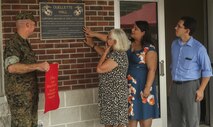 The Ouellette family (right)  of Cpl. Michael W. Ouellette, recipient of the Navy Cross, with Lt. Col. Theodore C. Bethea II (left), Advanced Infantry Battalion East commanding officer, unveil the bronze plaque dedicated to Ouellette’s sacrafice at Camp Geiger on Marine Corps Installation East Aug. 31. Ouellette was awarded posthumously for his actions during a combat patrol in the Now Zad district where an improvised explosive devise left him critically wounded.
