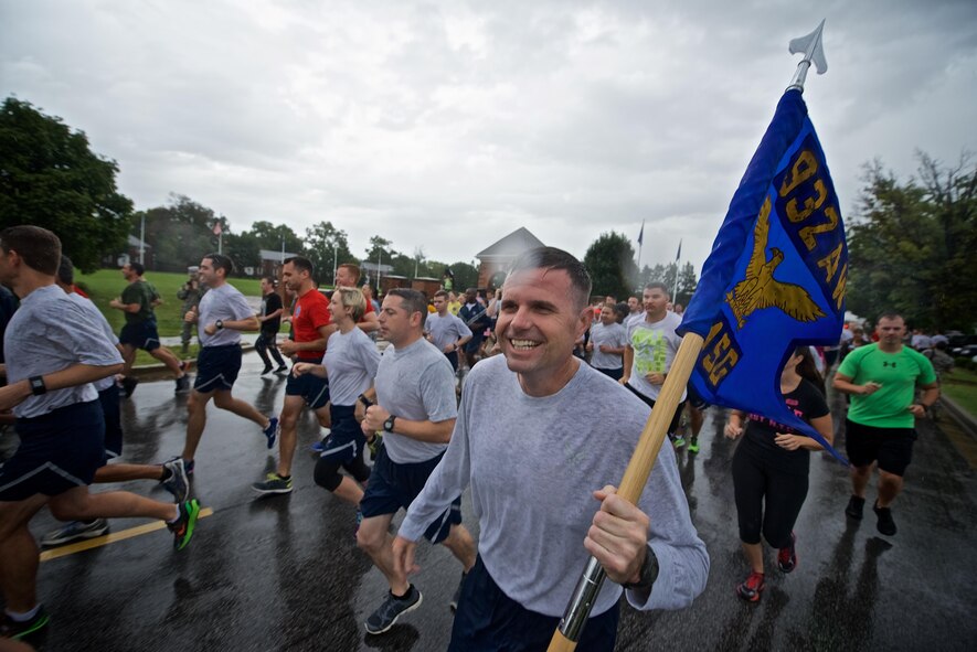 932nd Airlift Wing Command Chief, Chief Master Sgt. Chad Welch joins fellow runners, while carrying the 932nd AW guidon, for the Patriot Day 5K/10K held at Scott Air Force Base, Sep. 9, 2016, to honor the individuals who lost their lives on September 11, 2001.  Despite the heavy rain, runners were in good spirits and enjoyed the cooler temperatures.  (U.S. Air Force photo by Christopher Parr)