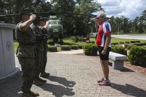 Retired Air Force Col. Gary West salutes the American flag during a flag while Marines present the recently folded flag to West at Marine Corps Air Station New River, Sept. 1. 
