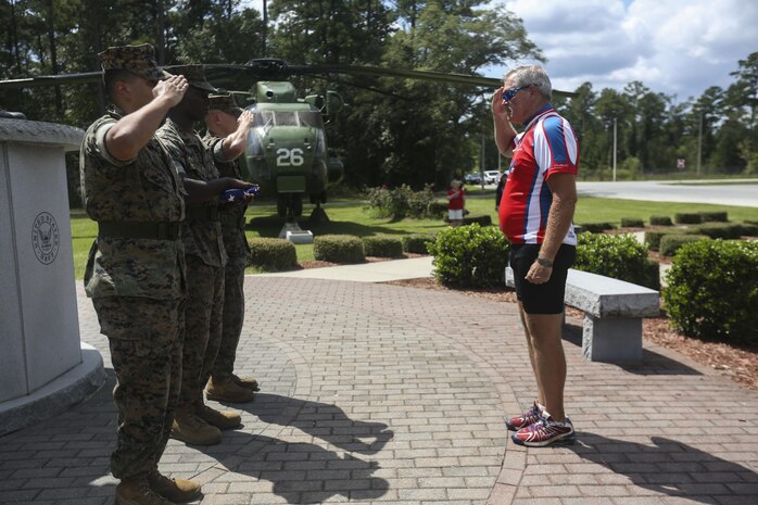 Retired Air Force Col. Gary West salutes the American flag during a flag while Marines present the recently folded flag to West at Marine Corps Air Station New River, Sept. 1. 