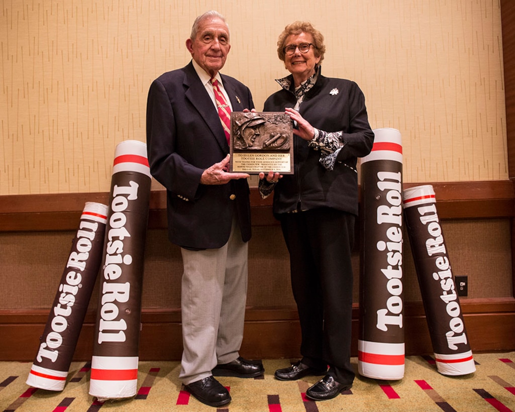 Lt. Gen. Richard E. Carey USMC (ret.) presents a plaque to Ellen R. Gordon, Chairman and Chief Executive Officer - Tootsie Roll Industries, Inc., at the Hyatt Regency, Dallas/Fort Worth International Airport, Sept. 8, 2016, for the support that Tootsie Rolls provided Marines during the Koran War. Marines requested a resupply of 60-millimeter mortars using code word “Tootsie Rolls”. Instead of the of mortar rounds, Marines received pallet loads of actual candy. The sugar provided instant energy for the starving Marines and many of the “The Chosin Few,” credit their survival to Tootsie Rolls. (Official Marine Corps photo by Sgt Alfredo Ferrer/ Released)