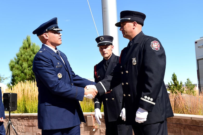 Col. David Miller Jr., 460th Space Wing commander, thanks Buckley Air Force Base firefighters for their service during a Patriot Day ceremony Sept. 9, 2016, on Buckley AFB, Colo. The attacks from Sept. 11, 2001, have greatly impacted the United States’ national security, along with national and international politics. (U.S. Air Force photo by Airman 1st Class Gabrielle Spradling/Released)