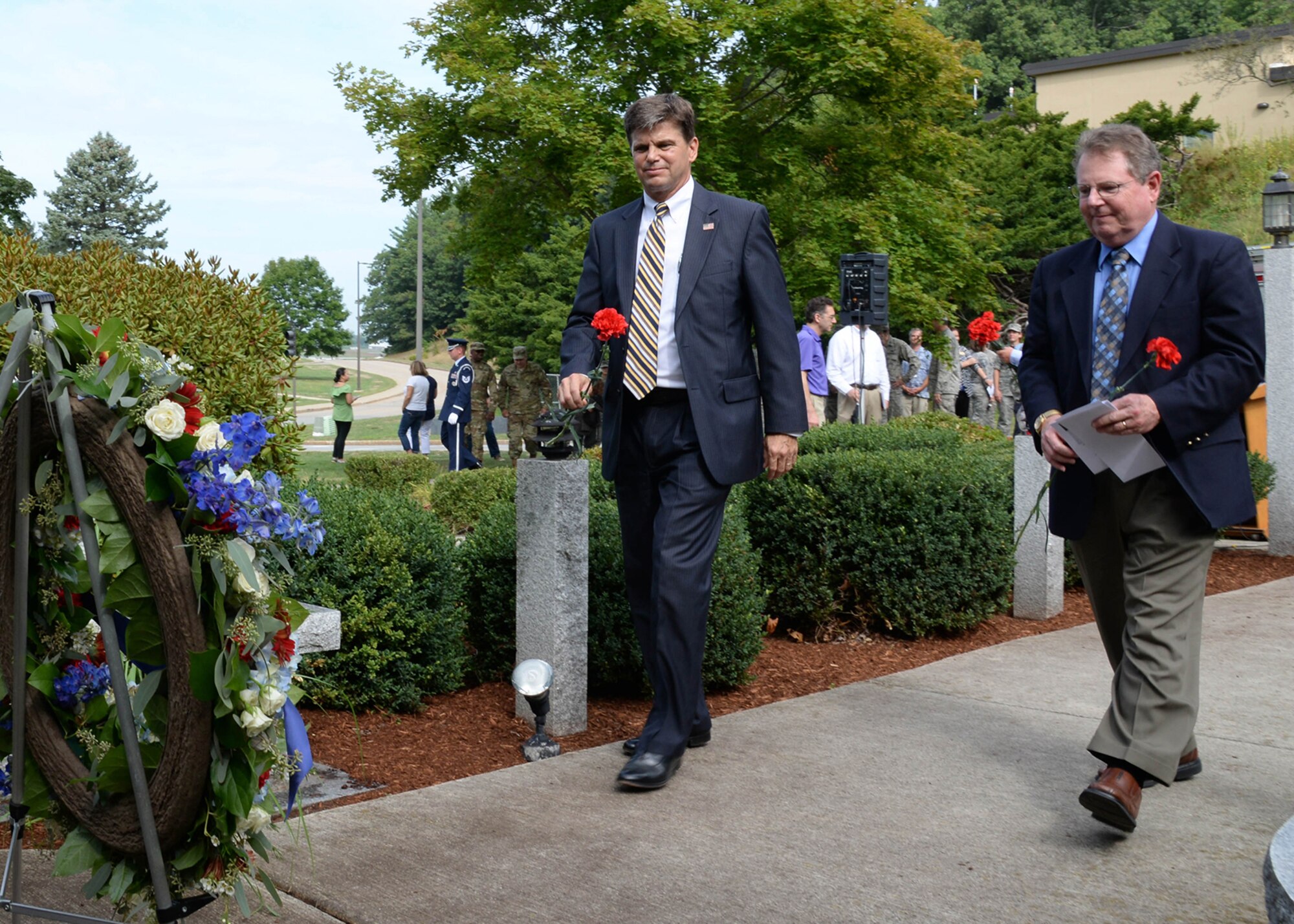 Scott Anderson, assistant director for operations at Massachusetts Institute of Technology’s Lincoln Laboratory, and Rick Reed, Bedford town manager, walk to place a carnation near a wreath following the 15th Anniversary Memorial Remembrance at Hanscom Air Force Base, Mass., Sept. 9. Anderson, who was the event's guest speaker and a Navy commander on 9/11, discussed where he was and how it impacted him. (U.S. Air Force photo by Linda LaBonte Britt) 