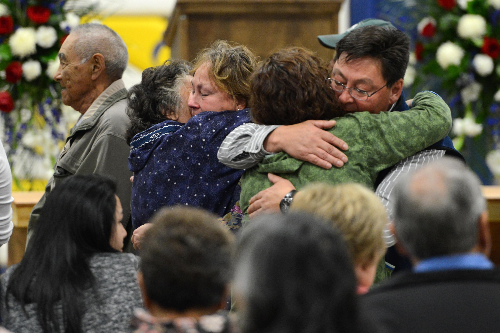 Friends and family of former Alaska National Guard Adjutant General Maj. Gen. John Schaeffer, Jr, share an embrace following the memorial service of the late general, at Kotzebue, Alaska, Aug. 31, 2016. Schaeffer enlisted in the Alaska National Guard in 1957, and served for 34 years.  Schaeffer was the first Alaska Native two-star general of the Alaska National Guard and commissioner of the Alaska Department of Military and Veterans Affairs. He is survived by Mary his wife of 56 years. (U.S. Air Force photo by Airman 1st Class Javier Alvarez)