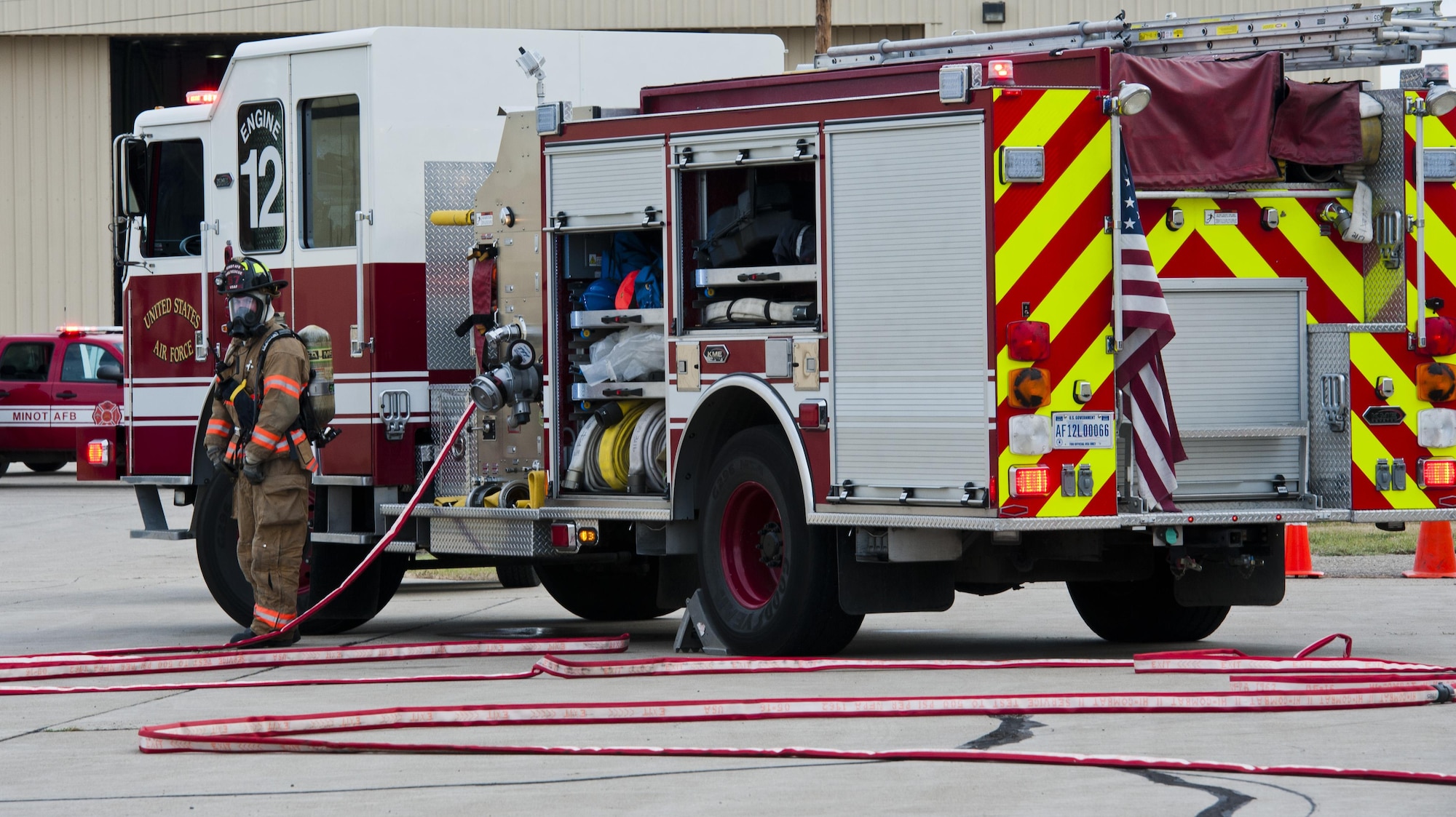 A 5th Civil Engineer Squadron firefighter waits by the fire truck during a fuel spill exercise at Minot Air Force Base, N.D., Sept. 8, 2016. During the annual training, three firefighters posted by the fire truck maintain communication with six firefighters who try to contain the fuel spill. (U.S. Air Force photo/Airman 1st Class Jonathan McElderry)