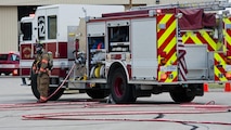 A 5th Civil Engineer Squadron firefighter waits by the fire truck during a fuel spill exercise at Minot Air Force Base, N.D., Sept. 8, 2016. During the annual training, three firefighters posted by the fire truck maintain communication with six firefighters who try to contain the fuel spill. (U.S. Air Force photo/Airman 1st Class Jonathan McElderry)
