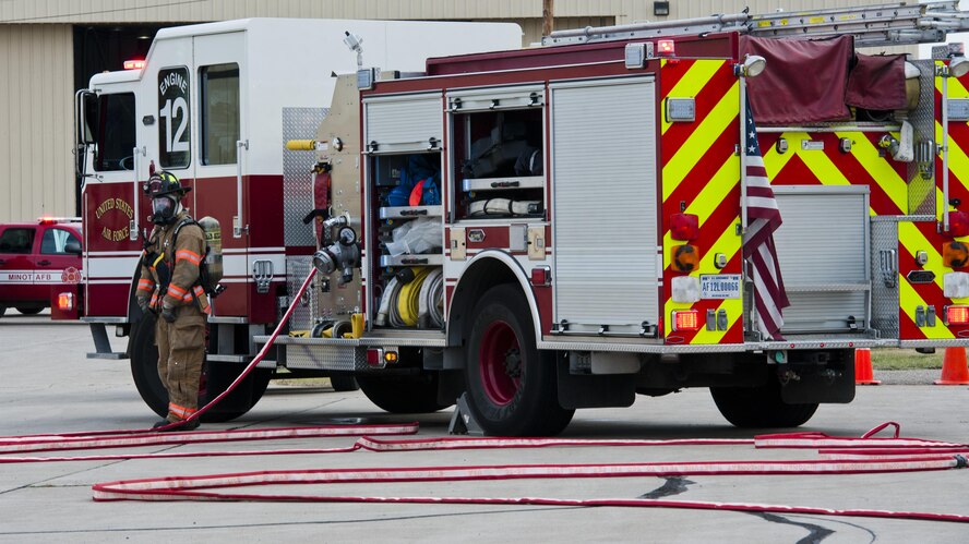 A 5th Civil Engineer Squadron firefighter waits by the fire truck during a fuel spill exercise at Minot Air Force Base, N.D., Sept. 8, 2016. During the annual training, three firefighters posted by the fire truck maintain communication with six firefighters who try to contain the fuel spill. (U.S. Air Force photo/Airman 1st Class Jonathan McElderry)
