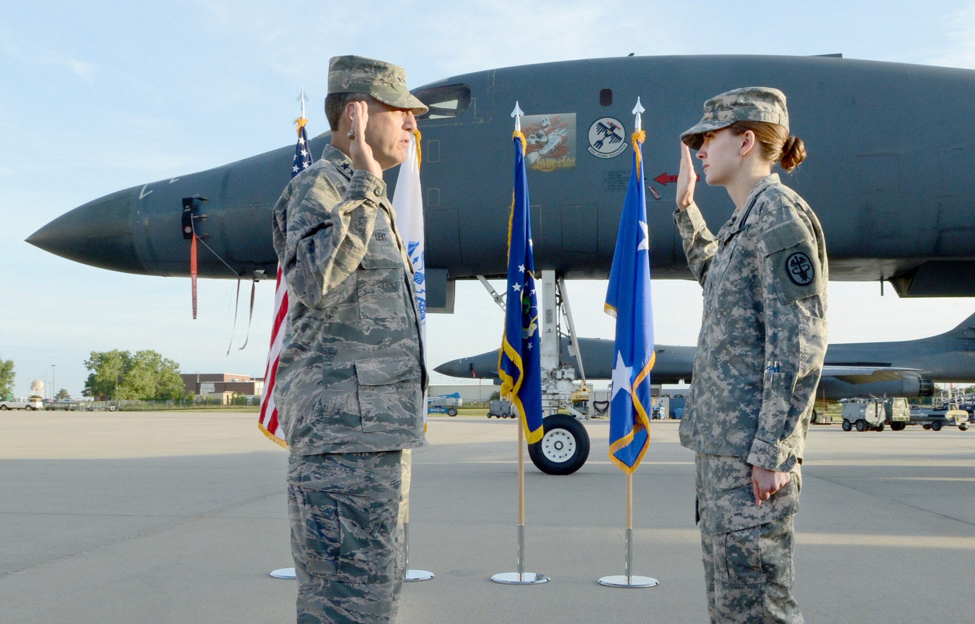 Air Force Sustainment Center Commander Lt. Gen. Lee K. Levy II reenlists Army Sgt. Ashley Plank in the shadow of a B-1B Lancer and in front of family and co-workers Aug. 26. Sergeant Plank has served for seven years and reenlisted for another six during the morning ceremony at the Maintenance Repair and Overhaul Technology Center. She is an animal care specialist at the Tinker Veterinary Clinic and is with the Oklahoma Branch of the Public Health Command-Central out of Fort Hood, Texas. (Air Force photo by Kelly White)
