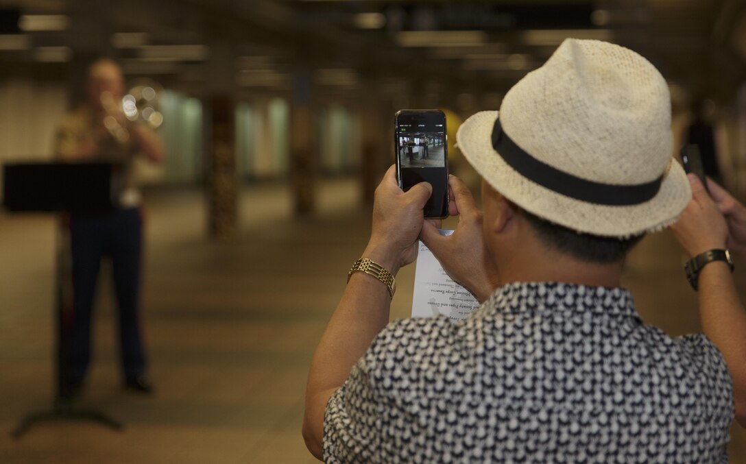 An onlooker photographs the Marine Corps Band New Orleans Brass Quintet’s performance in a New York City subway Aug. 28, 2016. The quintet’s performance was to promote the Marine Corps Reserve Centennial celebration. For 100 years, the Marine Corps Reserve has answered the call, serving as our nation’s crisis response force and expeditionary force in readiness. The centennial celebration is a way to honor that selfless service and commemorate the Marine Corps Reserve’s rich history, heritage and esprit de corps. The celebration is also a way for Reserve Marines to thank their families, employers and community for their continued support. (U.S. Marine Corps photo by Sgt. Ian Leones/Released)