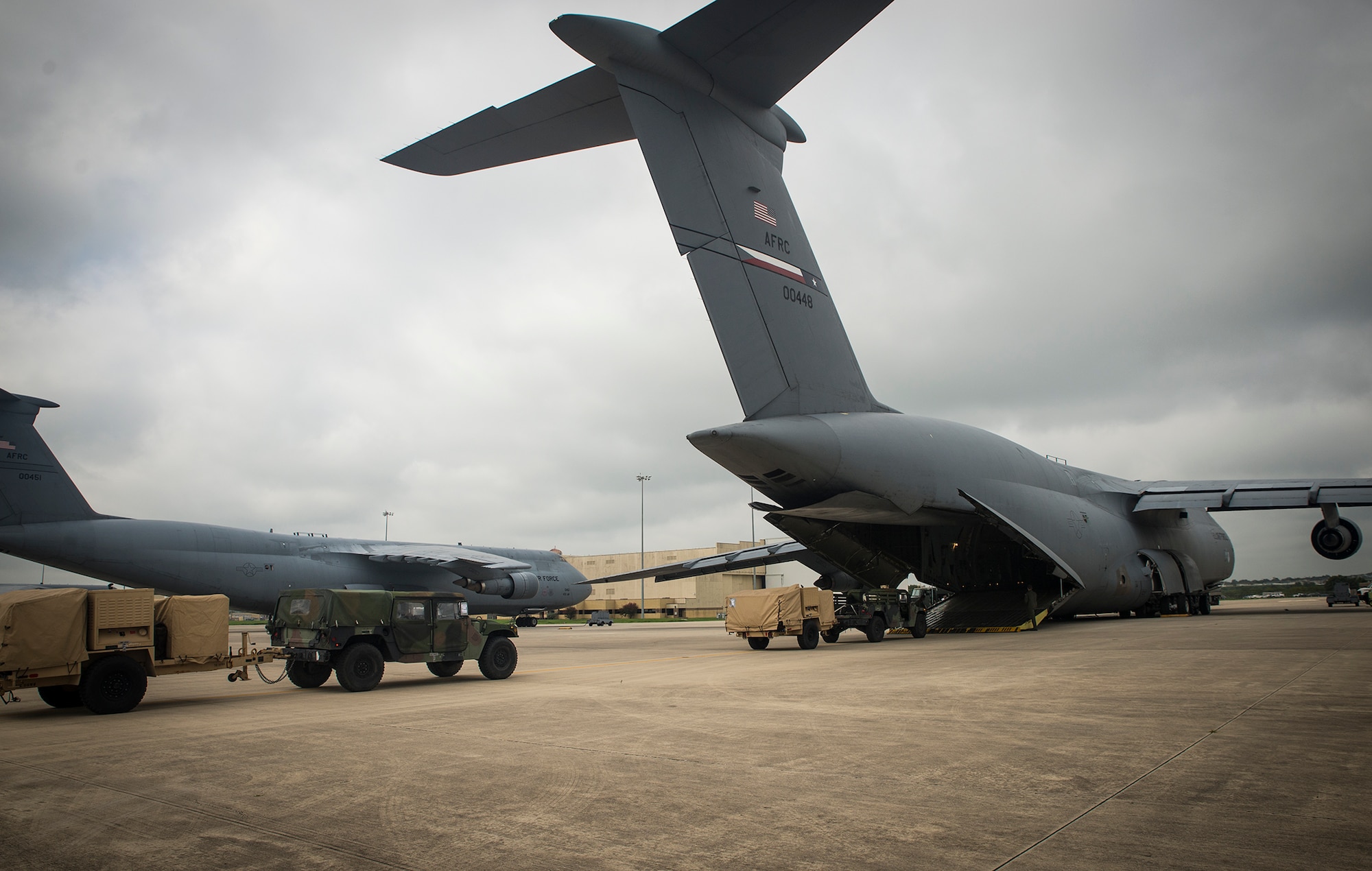 Loadmasters from the 68th Airlift Squadron load Humvees along with other equipment onto an awaiting C-5A Galaxy aircraft Sept. 8, 2016 at Joint Base San Antonio-Lackland, Texas. Soldiers from U.S. Army South’s Headquarters and Headquarters Battalion Soliders from JBSA-Fort Sam-Houston are taking part in a weeklong emergency deployment exercise at Naval Station Guantanamo Bay, Cuba. (U.S. Air Force photo by Benjamin Faske)