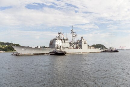 In this file photo, tugboats and auxiliary boats from Commander Fleet Activities Yokosuka maneuver the Ticonderoga-class guided-missile cruiser USS Shiloh (CG 67) into a dry-dock for a scheduled maintenance availability at U.S. Naval Ship Repair Facility and Japan Regional Maintenance Center (SRF JRMC) Yokosuka, July 20, 2016. During this maintenance availability, Shiloh will receive multiple repairs and upgrades performed by a combination of Shiloh's crew and SRF JRMC personnel. Shiloh is forward deployed to Yokosuka in support of security and stability in the Indo-Asia-Pacific region. 