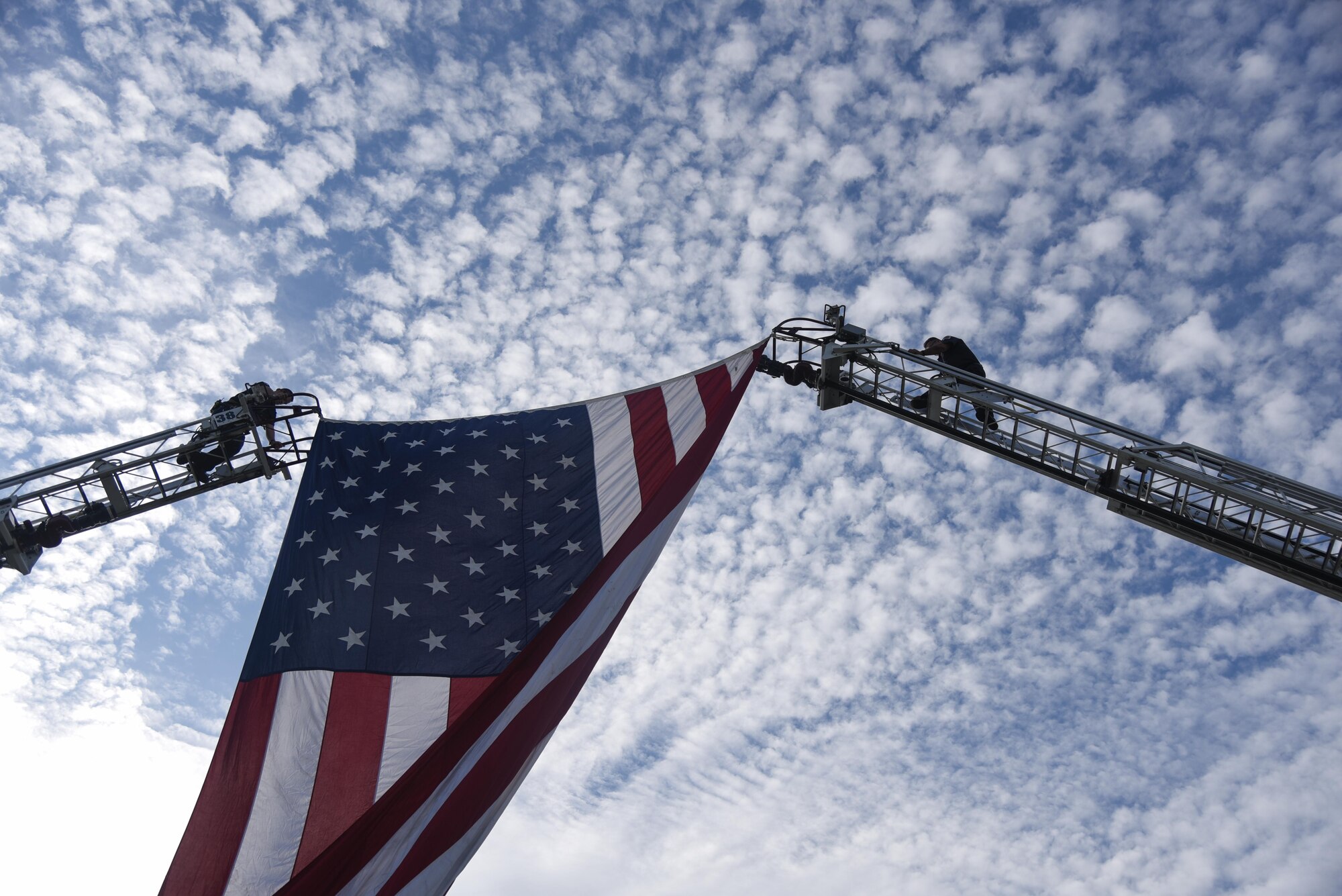 Prince George’s County Fire and Emergency Medical Services Department Firefighters climb firetruck ladders to secure the American flag at the 9/11 Remembrance Ceremony held at Heritage Park on Joint Base Andrews, Md., Sept. 9, 2016.  The ceremony paid tribute to the first responders and victims of the terrorist attacks on Sept. 11, 2001. (U.S. Air Force photo by Airman 1st Class Valentina Lopez)