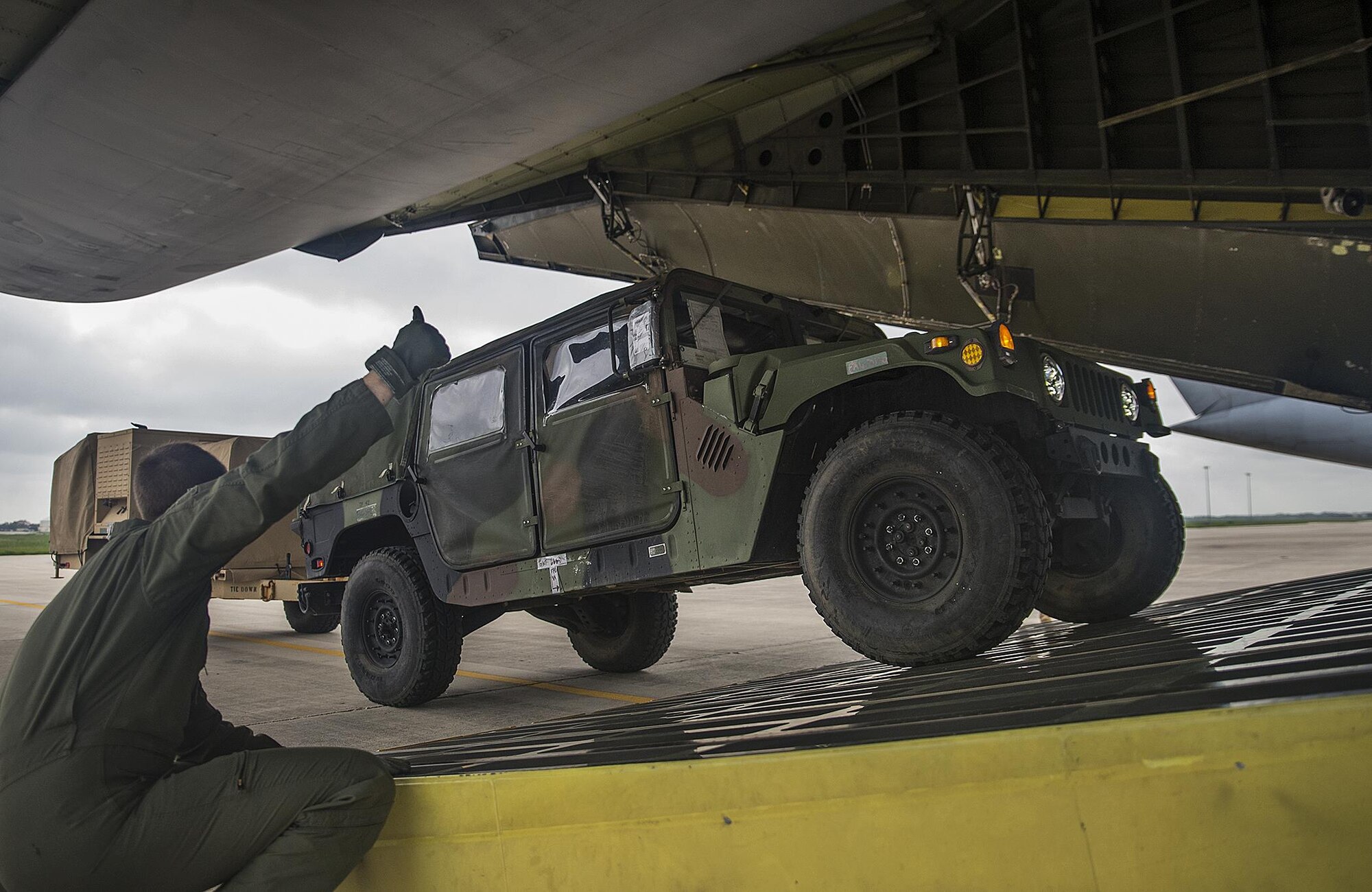 Senior Airman Joshua Green, 68th Airlift Squadron loadmaster, gives a "thumbs up" to load a Humvee onto an awaiting C-5A Galaxy aircraft Sept. 8, 2016 at Joint Base San Antonio-Lackland, Texas. U.S. Army South’s Headquarters and Headquarters Battalion Soldiers from JBSA-Fort Sam-Houston are taking part in a weeklong emergency deployment exercise at Naval Station Guantanamo Bay, Cuba. (U.S. Air Force photo by Benjamin Faske)
