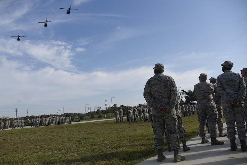 Joint Base Andrews military members observe a flyover of UH-1N Huey’s during the 9/11 Remembrance Ceremony held at Heritage Park on Joint Base Andrews, Md., Sept. 9, 2016. The ceremony paid tribute to the first responders and victims of the terrorist attacks on Sept. 11, 2001. (U.S. Air Force photo by Airman 1st Class Valentina Lopez)