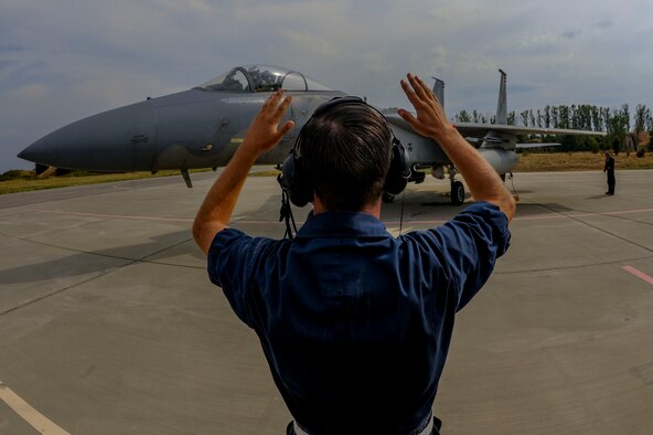 Sgt. Zechery Blackburn, a 194th Expeditionary Fighter Squadron crew chief, marshals an F-15C Eagle at Graf Ignatievo, Bulgaria, Sept. 8, 2016. Four of the squadron’s F-15Cs conducted joint NATO air policing missions with the Bulgarian Air Force to police the host nation’s sovereign airspace Sept. 9-16, 2016. (U.S. Air Force photo/Staff Sgt. Joe W. McFadden)