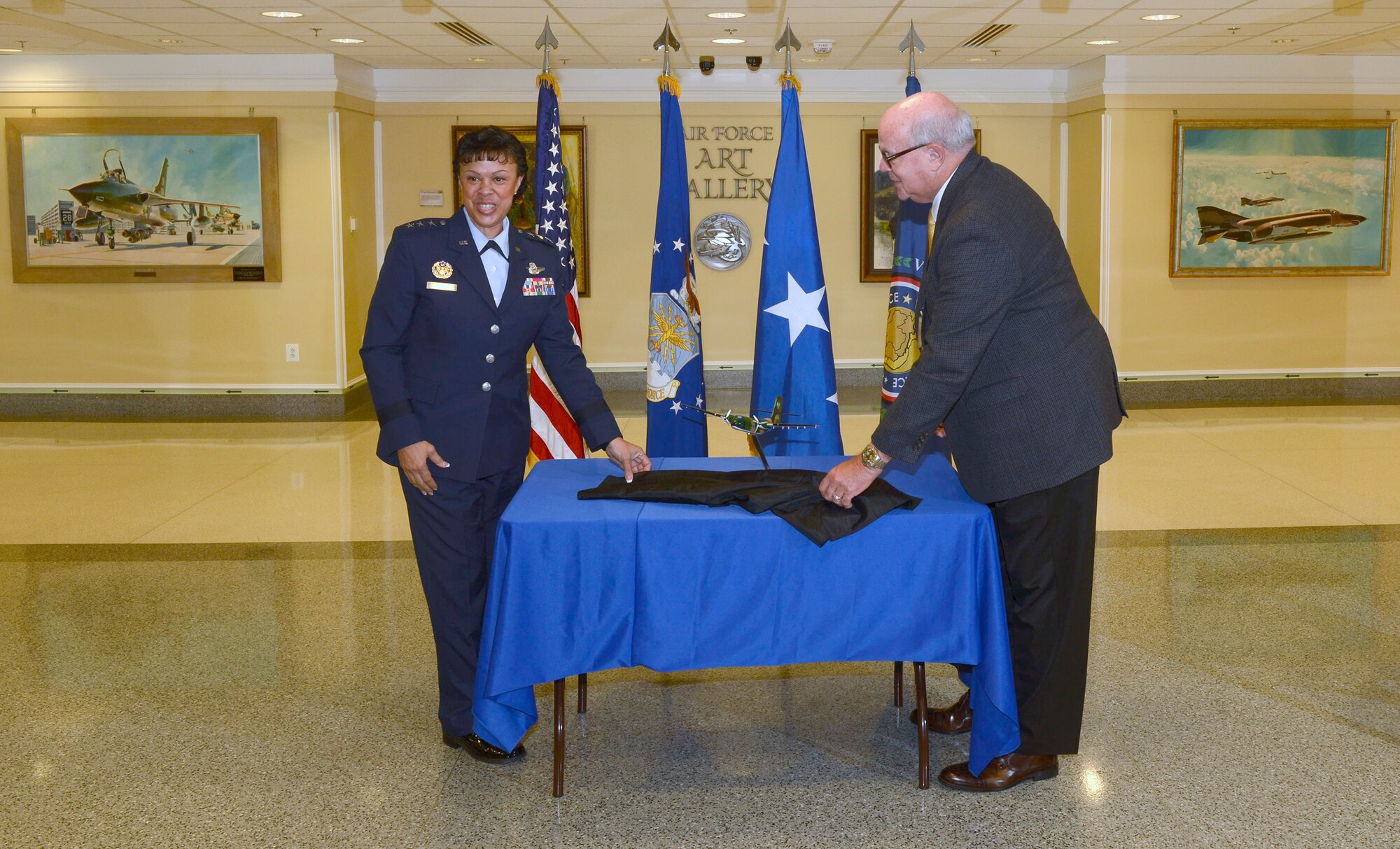 Lt. Gen. Stayce D. Harris, the Air Force assistant vice chief of staff, unveils a model C-7A Caribou with retired Master Sgt. John Schuepbach, a former Caribou administrative specialist, during a ceremony at the Pentagon in Washington, D.C., Sept. 9, 2016. Schuepbach handcrafted and donated this scale model to be placed in the Pentagon’s Wings Through Time display. (U.S. Air Force photo/Andy Morataya)