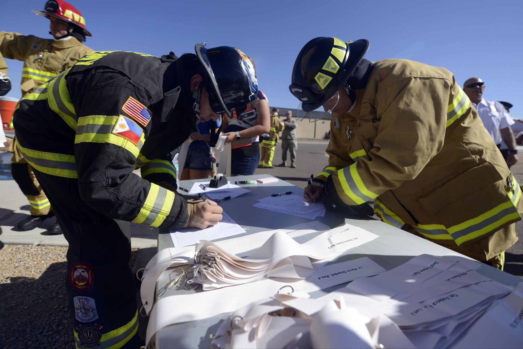 Luke Air Force Base firefighters fill out a form prior to walking up the air control tower during the 9/11 Memorial Ceremony Sept. 9, 2016 at Luke Air Force Base, Ariz. The symbolic act recreated the race for first responders to evacuate people from the World Trade Center towers during the attacks on Sept. 11, 2001. (U.S. Air Force photo by Senior Airman Devante Williams)