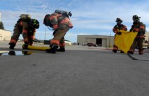 Firefighters from the 5th Civil Engineer Squadron unroll spill absorbent pads at Minot Air Force Base, N.D., Sept. 8, 2016. The firefighters used the pads to immediately stop spills and was part of an exercise that simulated a 6000 gallon fuel spill as part of an annual requirement for training. (U.S. Air Force photo by Staff Sgt. Chad Trujillo)