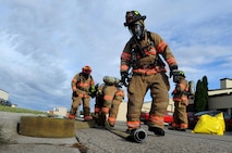 Firefighters from the 5th Civil Engineer Squadron unroll hoses at Minot Air Force Base, N.D., Sept. 8, 2016. The hoses were used to help contain a simulated fuel spill which was part of an annual training requirement. (U.S. Air Force photo by Staff Sgt. Chad Trujillo)