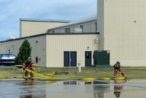 Firefighters from the 5th Civil Engineer Squadron unroll a hose at Minot Air Force Base, N.D., Sept. 8, 2016. The hose was used to help contain a simulated contaminate from a fuel spill and was part of annual training to keep the firefighters ready for an actual fuel spill emergency. (U.S. Air Force photo by Staff Sgt. Chad Trujillo)