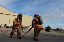 Firefighters from the 5th Civil Engineer Squadron unroll a hose at Minot Air Force Base, N.D., Sept. 8, 2016. The firefighters were conducting a fuel spill exercise and is part of an annual requirement for training. (U.S. Air Force photo by Staff Sgt. Chad Trujillo)