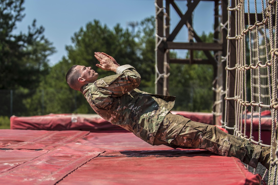 Army Sgt. 1st Class Jason Scott negotiates the cargo net obstacle during the 2016 Army Reserve Drill Sergeant of the Year competition for the Army's Training and Doctrine Command at Fort Jackson in Columbia, S.C., Sept. 8, 2016.  Scott is a member of the Army Reserve. Army photo by Sgt. 1st Class Brian Hamilton