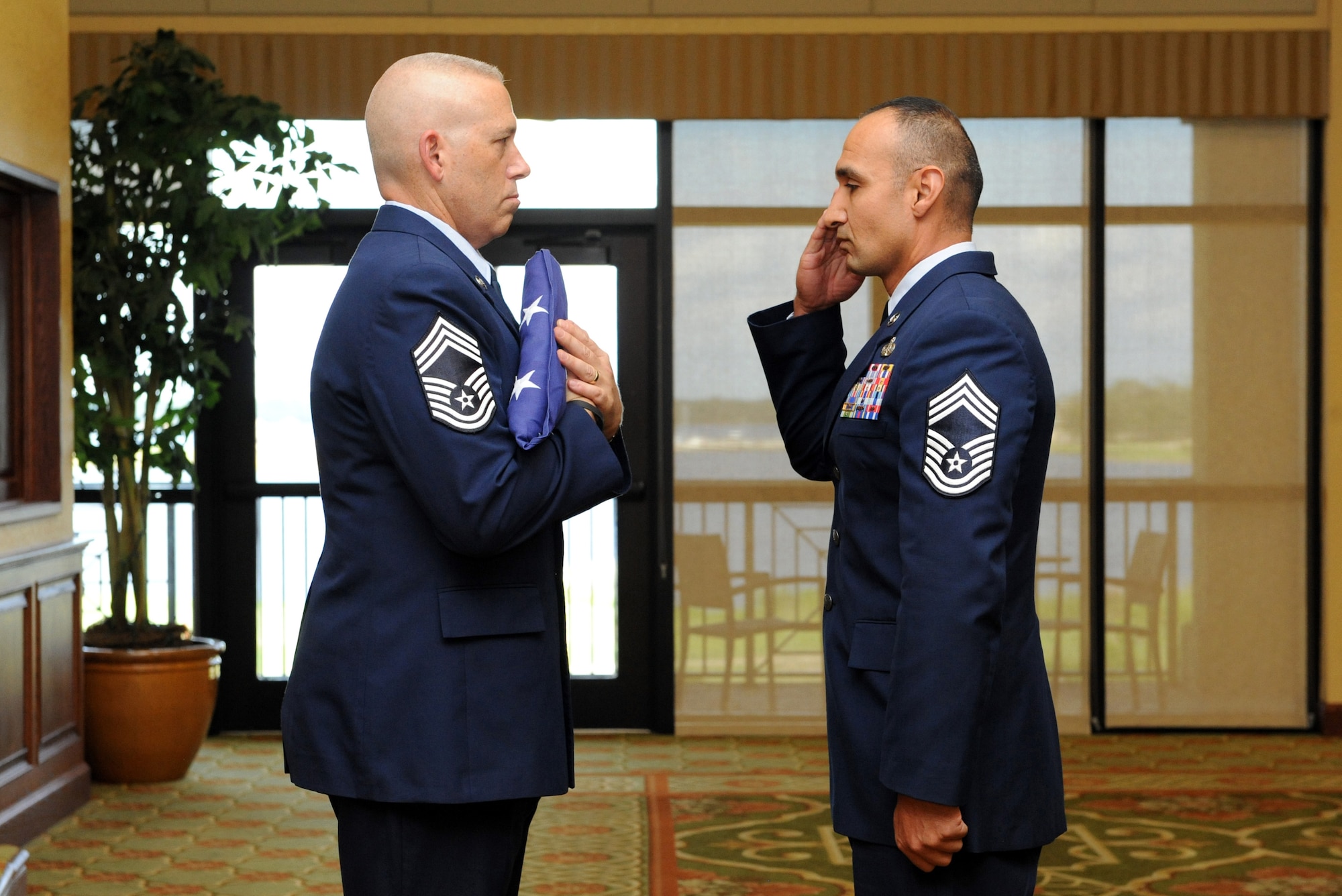 Chief Master Sgt. Robert Winters, 81st Training Group superintendent, is presented the U.S. flag by Chief Master Sgt. Reynaldo Garza, Jr., 85th Engineering Installation Squadron chief enlisted manager, during his retirement ceremony at the Bay Breeze Event Center Sept. 8, 2016, on Keesler Air Force Base, Miss. Winters retired with more than 29 years of military service and served multiple assignments in California, Louisiana, Georgia, Colorado, Korea, and the United Kingdom. He also worked as an electronic warfare officer in support of more than over 700 soldiers in multiple locations throughout Iraq. (U.S. Air Force photo by Kemberly Groue/Released)