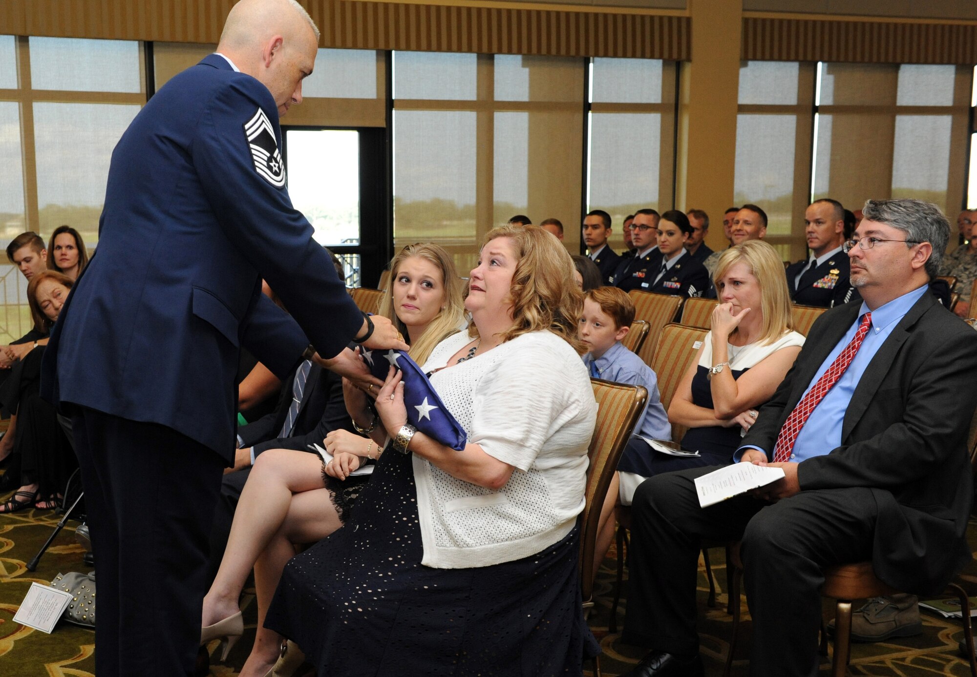 Chief Master Sgt. Robert Winters, 81st Training Group superintendent, presents the U.S. flag to his wife, Terresa, during his retirement ceremony at the Bay Breeze Event Center Sept. 8, 2016, on Keesler Air Force Base, Miss. Winters retired with more than 29 years of military service and served multiple assignments in California, Louisiana, Georgia, Colorado, Korea and the United Kingdom. He also worked as an electronic warfare officer in support of more than 700 soldiers in multiple locations throughout Iraq. (U.S. Air Force photo by Kemberly Groue/Released)