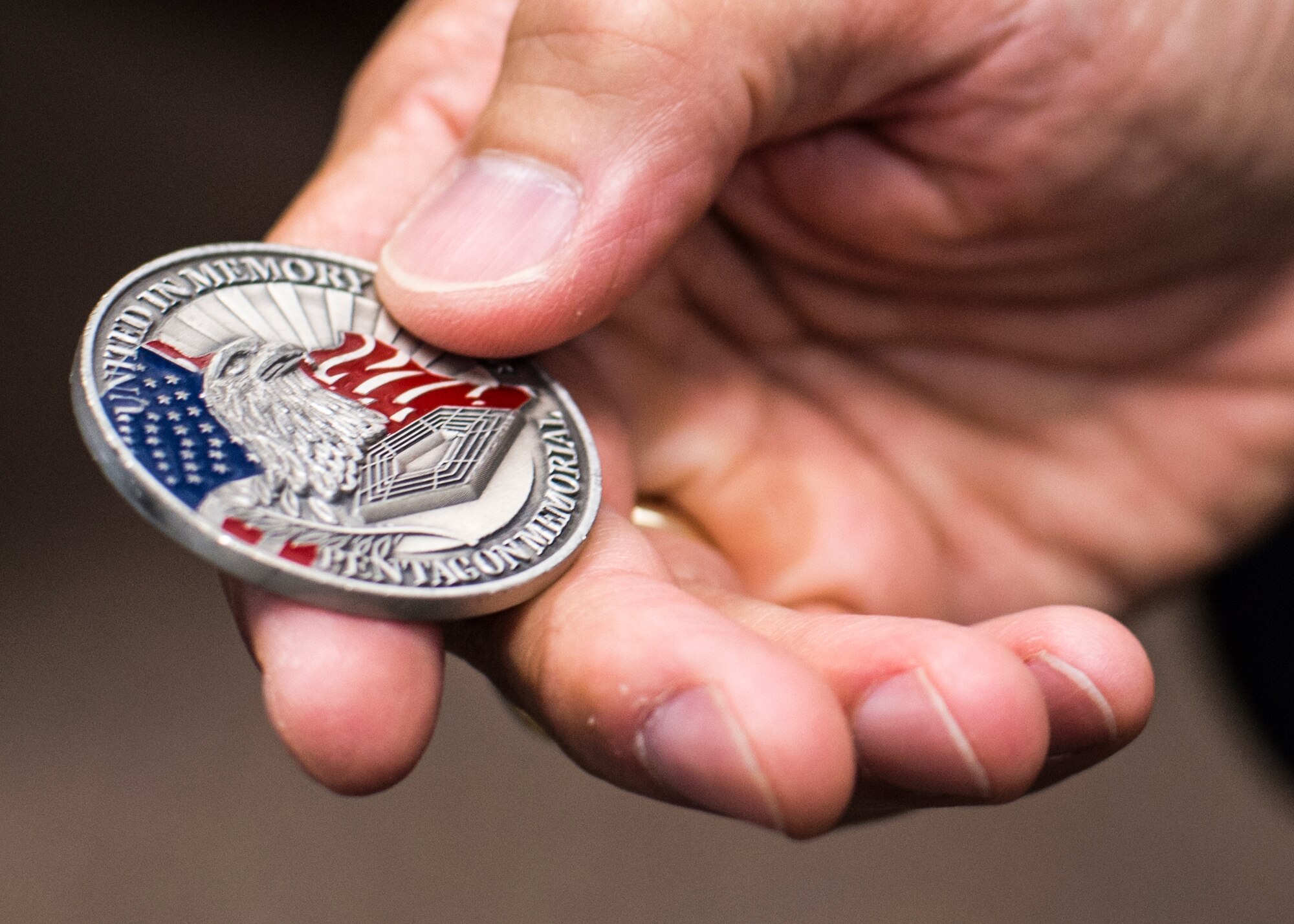Col. Houston Cantwell, the 49th Wing commander, holds a 9/11 commemoration coin at Holloman Air Force Base, N.M., on Sept. 8, 2016. Cantwell was working as an Air Force intern at the Pentagon when the third hijacked airliner struck the west side, just a corner away from his office. (U.S. Air Force photo by Senior Airman Emily Kenney) 