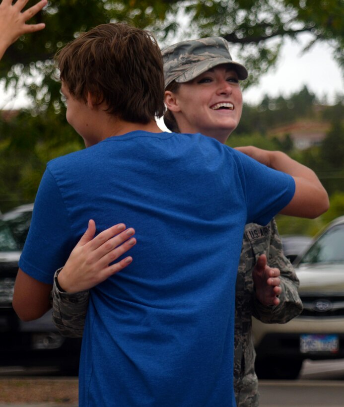 Senior Airman Amber Burns, a nondestructive inspection journeyman assigned to the 28th Maintenance Squadron, hugs a student during the 2nd Annual Patriot Day parade at Southwest Middle School in Rapid City, S.D., Sept. 9, 2016. Over 1,000 students and faculty members from both Southwest Middle School and Corral Drive Elementary School participated in the event, showing their thanks and appreciation for local military members and first responders. (U.S. Air Force photo by Airman 1st Class Denise M. Jenson)