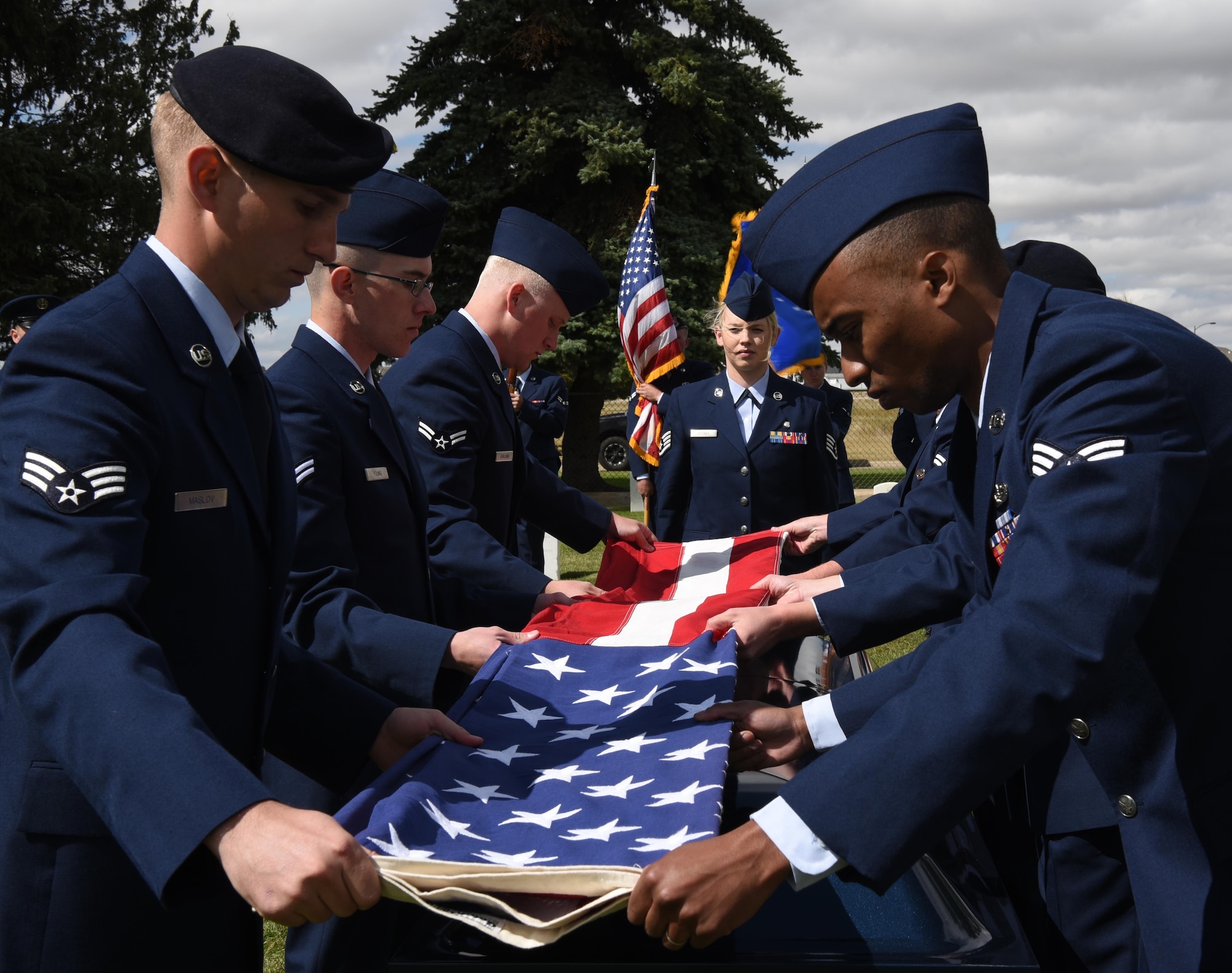 Honor guard graduates fold the flag during a mock funeral on F.E. Warren Air Force Base, Wyo. Sept. 9. Graduates showcased their precision movements during the ceremony. (U.S. Air Force photo by Airman 1st Class Breanna Carter)