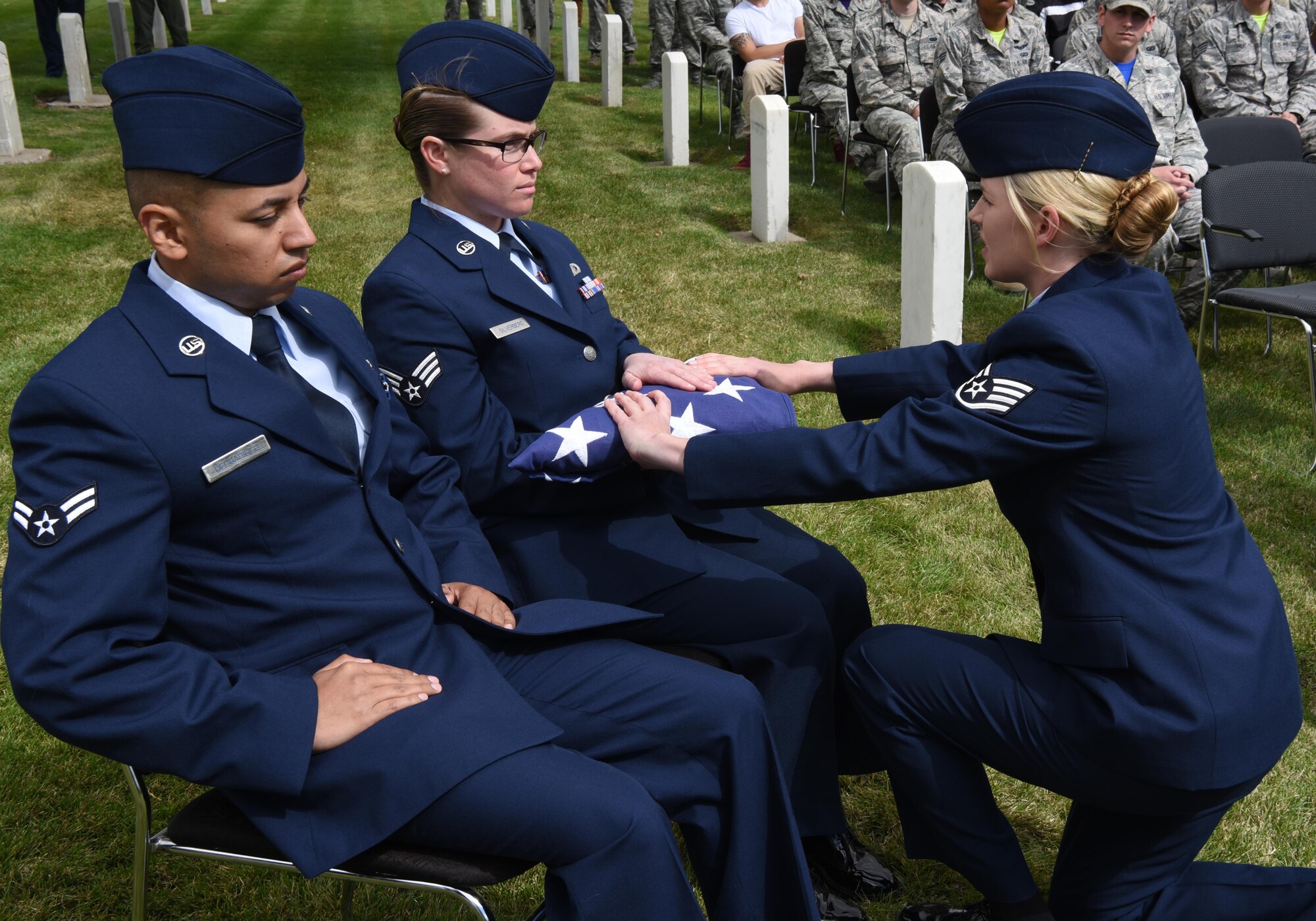 Staff Sgt. Kayla Scobey, 90th Medical Operations Squadron honor guard graduate, presents the folded flag during a mock funeral on F.E. Warren Air Force Base, Wyo. Sept. 9. Graduates showcased their precision movements during the ceremony. (U.S. Air Force photo by Airman 1st Class Breanna Carter)