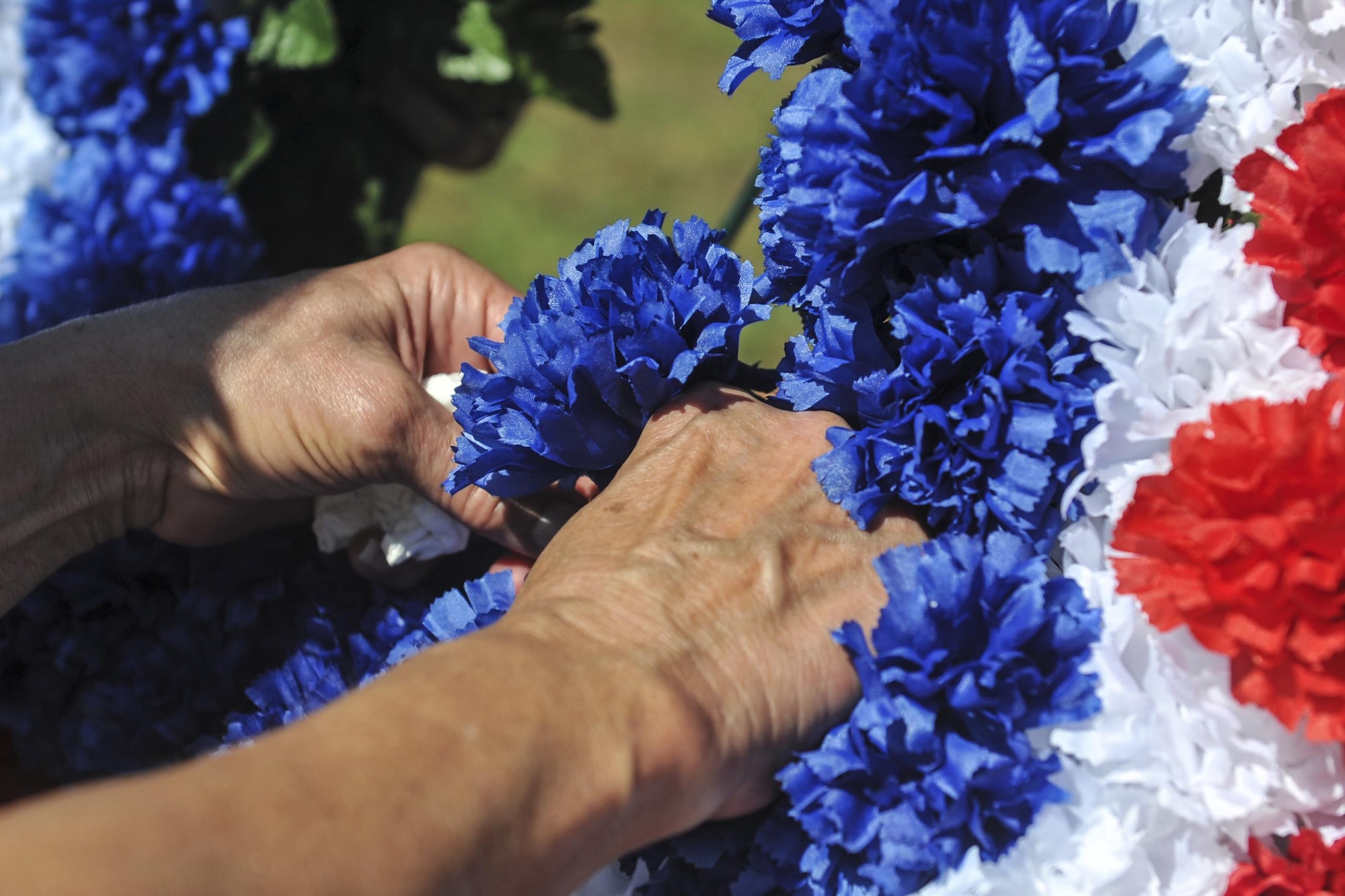 A family member of the AC-47 Spooky Gunship Brotherhood puts a flower on a wreath in remembrance of a fallen loved one during a plaque dedication ceremony at the Hurlburt Field Air Park, Fla., Sept. 9, 2016. The Spooky brotherhood purchased a memorial plaque with the names of fallen AC-47 crewmembers, who served in Southeast Asia. (U.S. Air Force photo by Airman Dennis Spain)