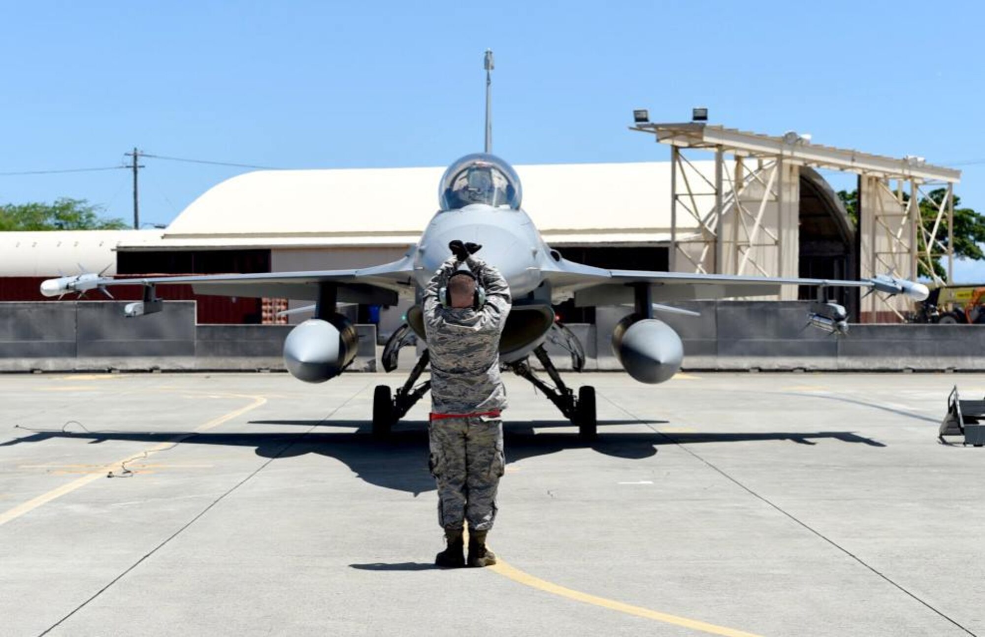 Tech. Sgt. Adam Flood, a crew chief with the 149th Fighter Wing, Texas Air National Guard, headquartered at Joint Base San Antonio-Lackland, Texas, marshals an F-16 Fighting Falcon at Joint Base Pearl Harbor Hickam, Hawaii, Aug. 18, 2016. Flood participated in Sentry Aloha 2016, a large-scale fighter exercise hosted by the Hawaii Air National Guard. (U.S. Air National Guard photo by Tech. Sgt. Rebekkah Jandron)