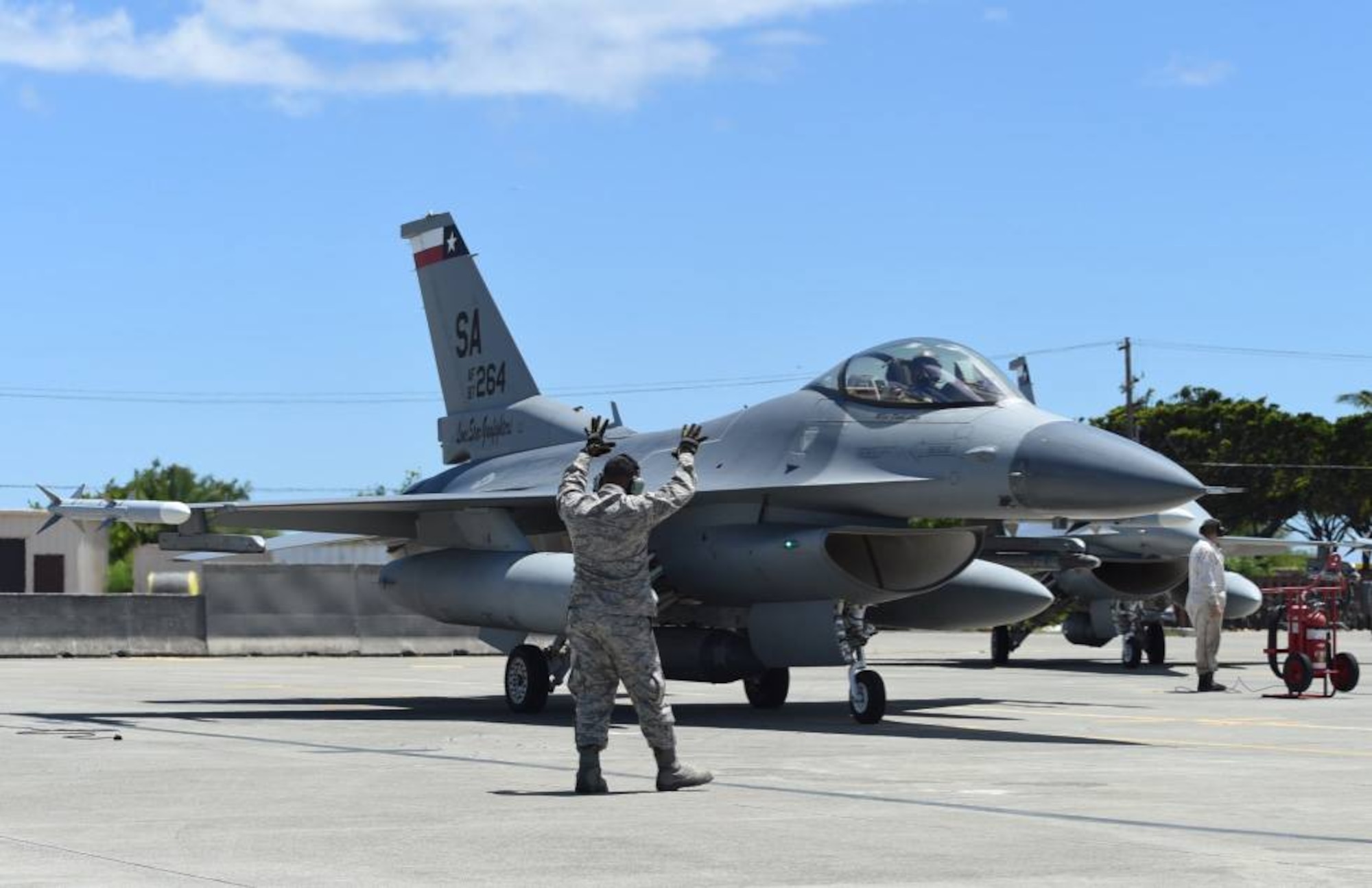 Tech. Sgt. Kevin Yamaguchi, a crew chief with the 149th Fighter Wing, Texas Air National Guard, headquartered at Joint Base San Antonio-Lackland, Texas, marshals an F-16 Fighting Falcon at Joint Base Pearl Harbor Hickam, Hawaii, Aug. 18, 2016. Yamaguchi participated in Sentry Aloha 2016, a large-scale fighter exercise hosted by the Hawaii Air National Guard (U.S. Air National Guard photo by Tech. Sgt. Rebekkah Jandron)