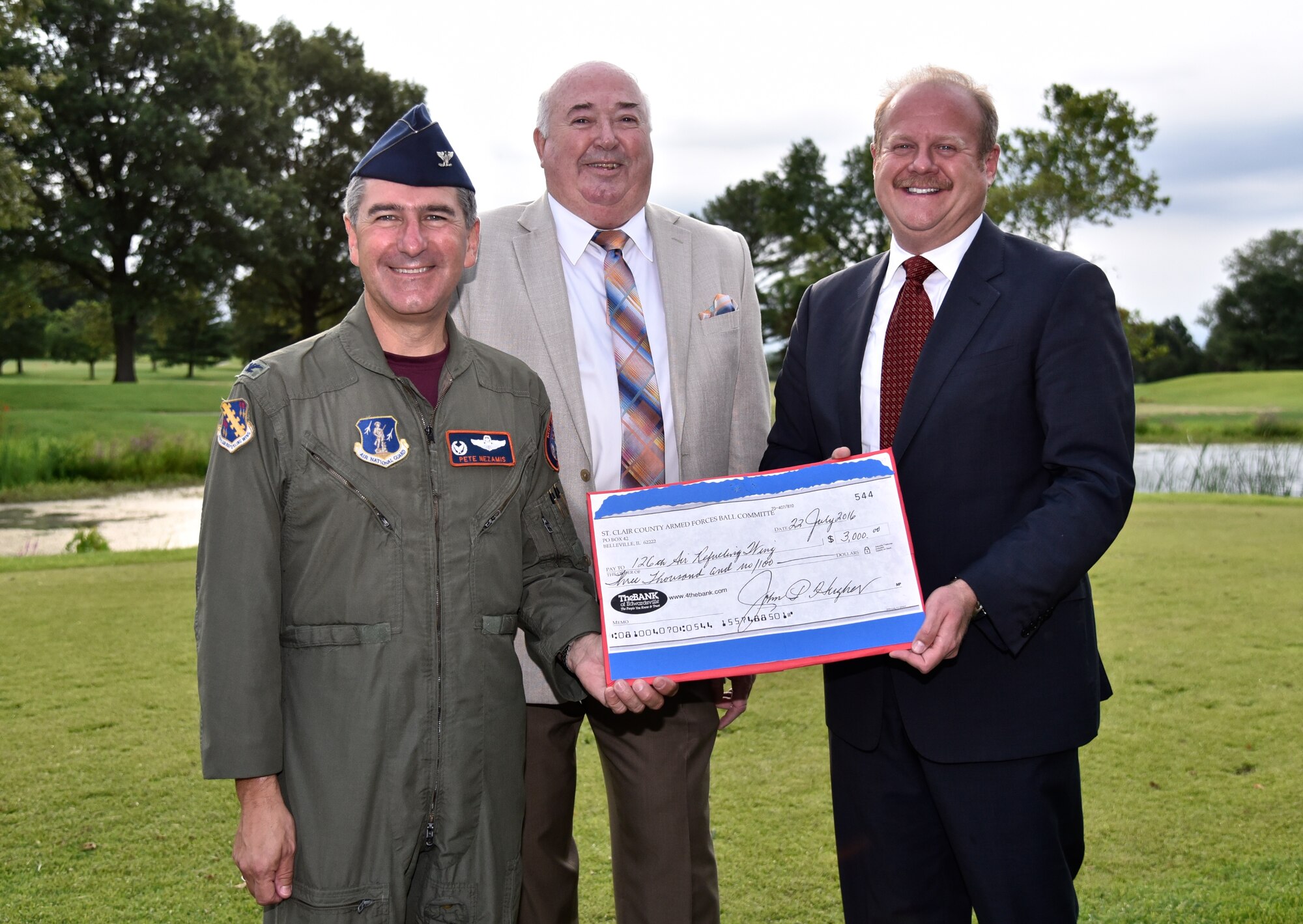 Colonel Peter Nezamis, commander of the 126th Air Refueling Wing, receives a $3,000 St. Clair County Military Ball donation for the Illinois Air National Guard unit from John Hughes, director of military affairs, St. Clair County, and St. Clair County Chairman Mark Kern.