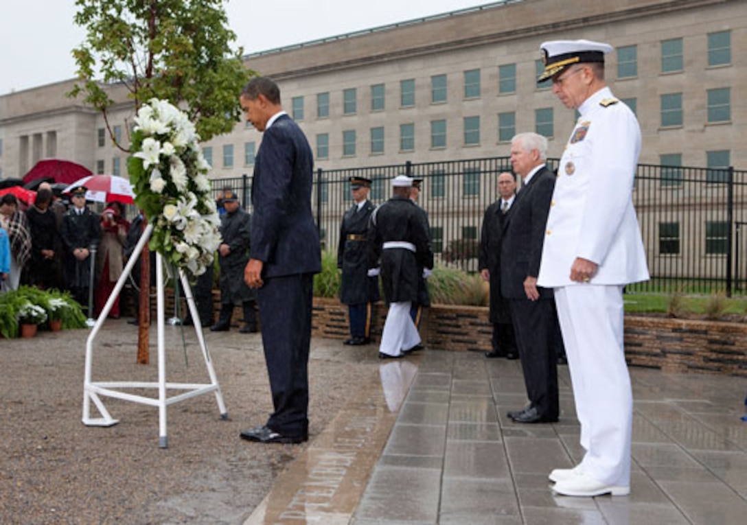 President Barack Obama pauses for a moment of silence after laying a wreath at the Pentagon Memorial, Sept. 11, 2009, with Defense Secretary Robert Gates and Navy Adm. Mike Mullen, chairman of the Joint Chiefs of Staff. The leaders were participating in a ceremony to honor the 184 victims killed when American Airlines Flight 77 crashed into the Pentagon during a terrorist attack 8 years ago. White House photo by Pete Souza