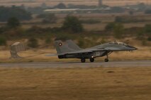 A Bulgarian air force Mikoyan MiG-29 Fulcrum fighter aircraft assigned to the 3rd Air Force Base flies releases its parachute during a landing on the flightline during joint NATO air policing at Graf Ignatievo, Bulgaria, Sept. 8, 2016. Four California and Massachusetts Air National Guards’ F-15C Eagle fighter aircraft and approximately 75 Airmen from the 194th Expeditionary Fighter Squadron deployed to Graf Ignatievo, Bulgaria, and will stand ready as interceptors, prepared to quickly react to any violations and infringements for policing of Bulgarian airspace Sept. 9-16, 2016. The squadron forward deployed to Graf Ignatievo from Campia Turzii, Romania, where they serve on a theater security package deployment to Europe as a part of Operation Atlantic Resolve.  (U.S. Air Force photo by Staff Sgt. Joe W. McFadden/Released)