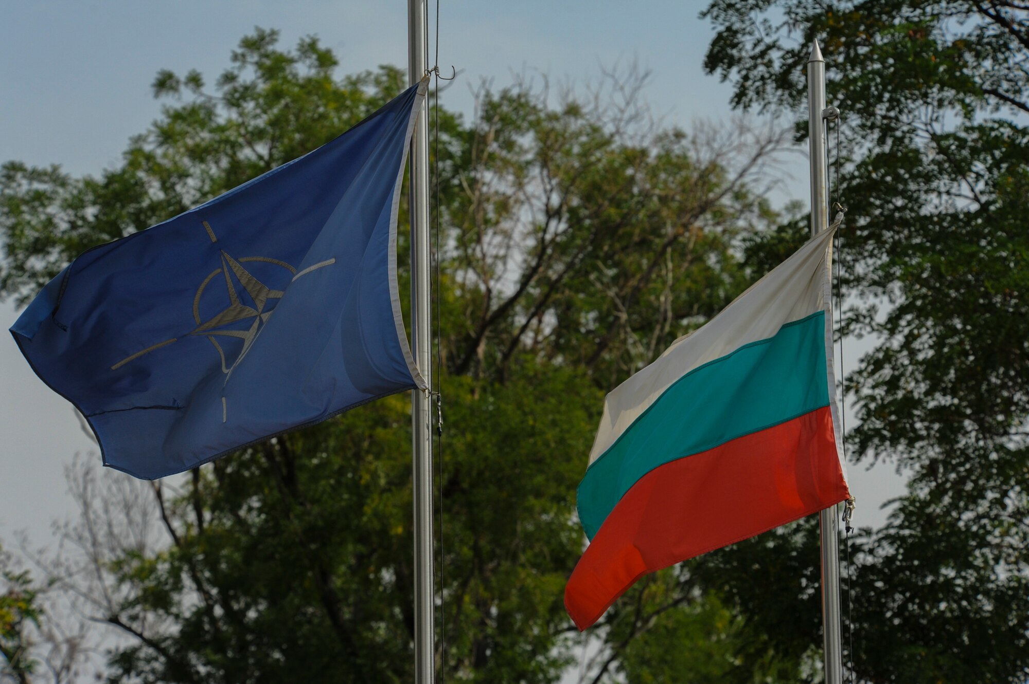 The NATO and Bulgarian flags fly inside the main entrance of Graf Ignatievo, Bulgaria, Sept. 9, 2016.  Four California and Massachusetts Air National Guards’ F-15C Eagle fighter aircraft and approximately 75 Airmen from the 194th Expeditionary Fighter Squadron deployed to Graf Ignatievo, Bulgaria, and will stand ready as interceptors, prepared to quickly react to any violations and infringements for policing of Bulgarian airspace Sept. 9-16, 2016. The squadron forward deployed to Graf Ignatievo from Campia Turzii, Romania, where they serve on a theater security package deployment to Europe as a part of Operation Atlantic Resolve.  (U.S. Air Force photo by Staff Sgt. Joe W. McFadden/Released)