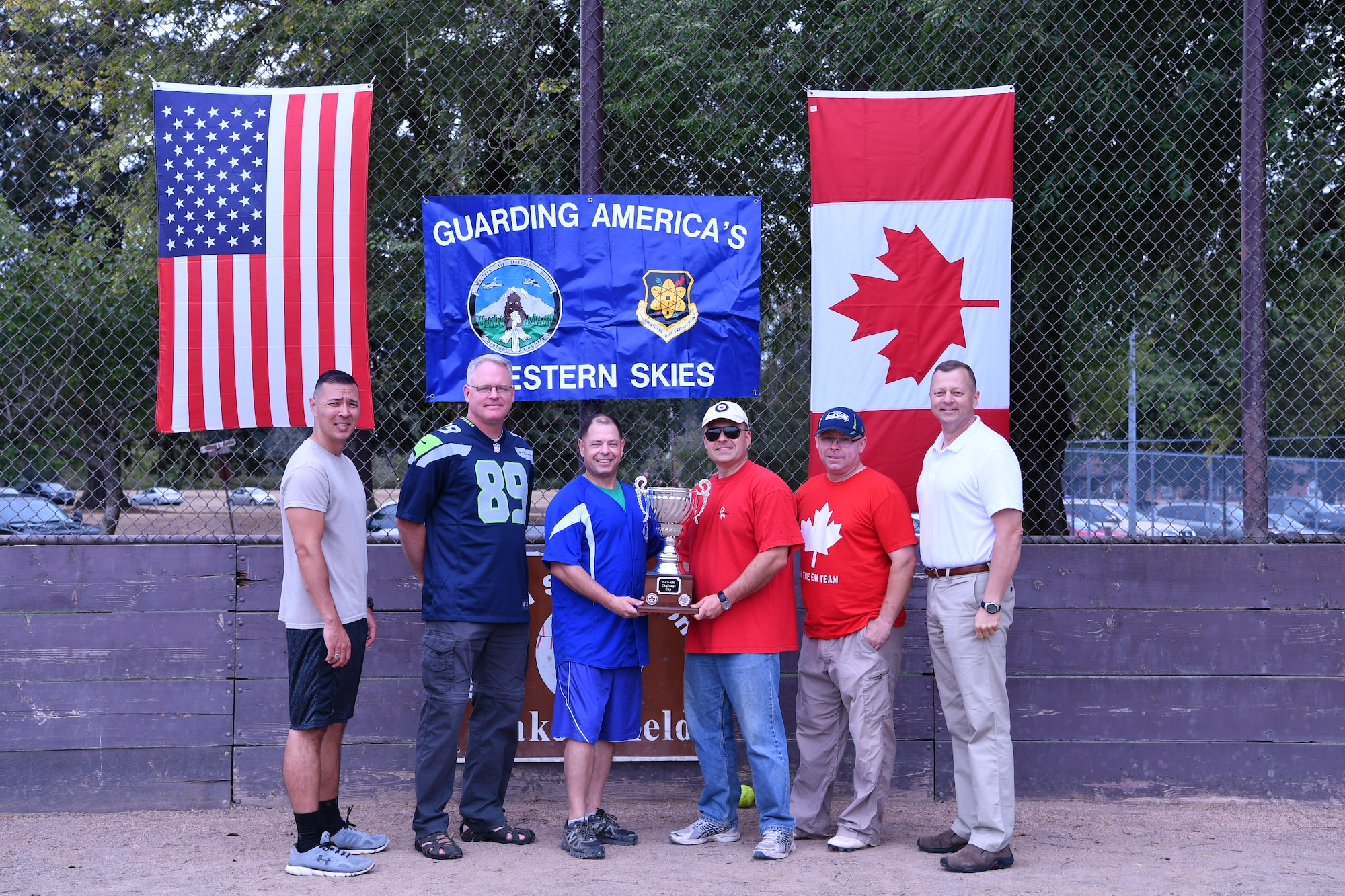 The Western Air Defense Sector’s CAN-AM Challenge Cup was officially passed from Canadian Detachment commander, Lt. Col. Matthew Wappler, to Chief Master Sgt. Daniel Rebstock, 225th Support Squadron superintendent, after the U.S. won the annual softball game by a final score of 22 to 7.  Pictured from left to right are: Chief Master Sgt. Allan Lawson, Col. William Krueger, Chief Master Sgt. Daniel Rebstock, Canadian Lt. Col. Matthew Wappler, Canadian Warrant Officer Richard Martin, and Col. Gregor Leist. (U.S. Air National Guard photo by Capt. Kimberly D. Burke)
